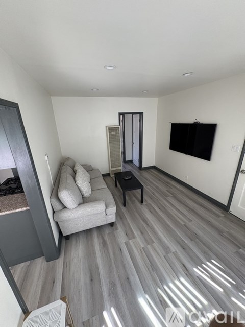 A living room with a grey couch and a black coffee table.