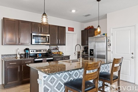 A kitchen with brown cabinets and a granite countertop.