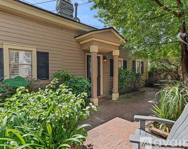 A house with a front porch and a bench in front of it.