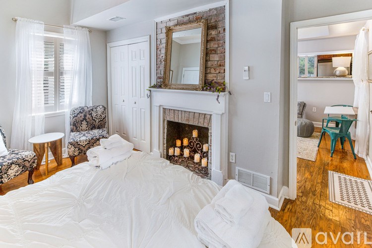 A bedroom with a large bed and a fireplace.