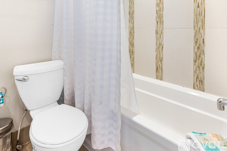 A white toilet sits next to a bathtub in a bathroom.