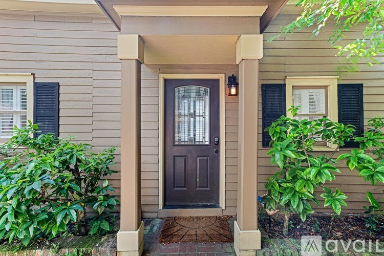 A house with a brown door and a window with black shutters.