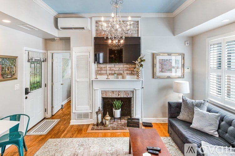 A living room with a fireplace and a chandelier.