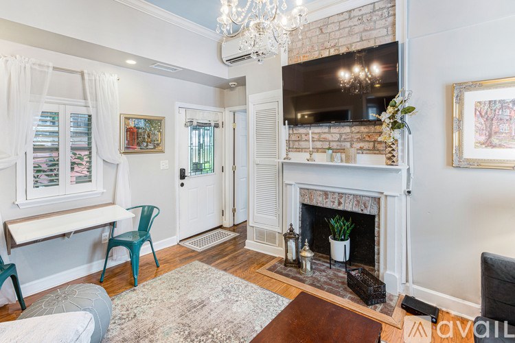 A living room with a fireplace and a chandelier.