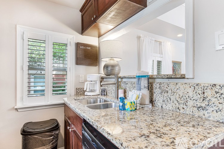 A kitchen with a granite countertop and a coffee maker.