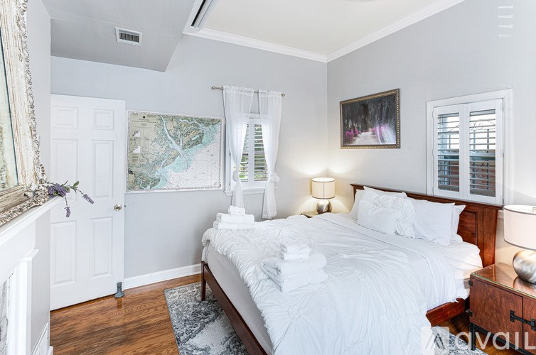 A bedroom with a large bed and a painting on the wall.