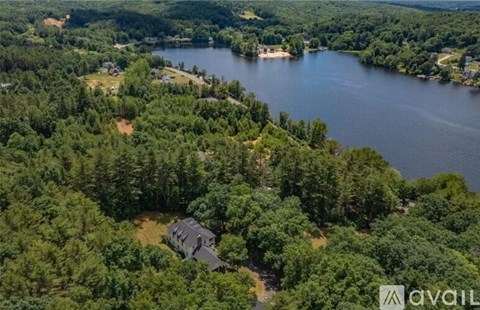 A house is surrounded by trees and a lake.