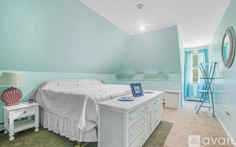 A bedroom with a bed, nightstand, and chair.
