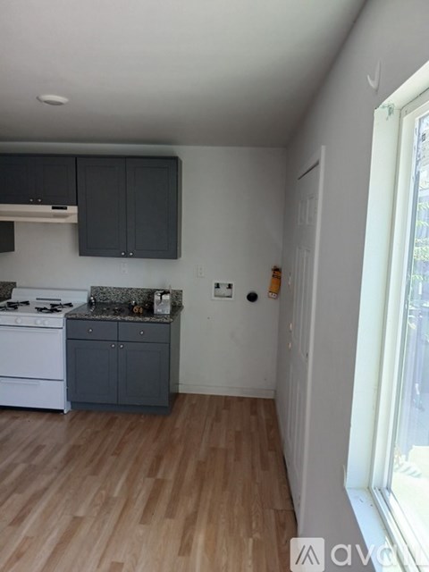 A kitchen with a white stove top oven and a white dishwasher.
