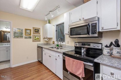 A kitchen with white cabinets and a black stove top.