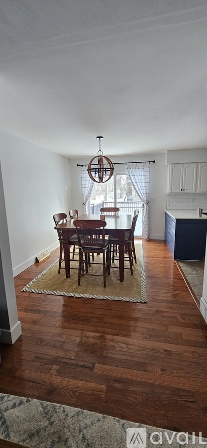 A dining room with a wooden table and chairs.