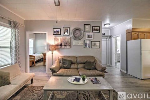 A living room with a brown couch and a coffee table in the center.