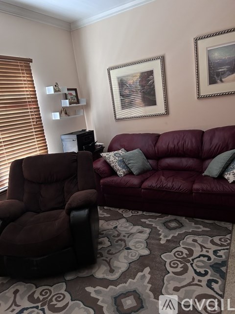 A living room with a red couch and a brown recliner.