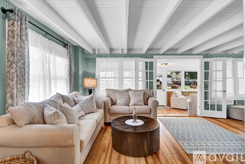 A living room with a white couch and a wooden coffee table.