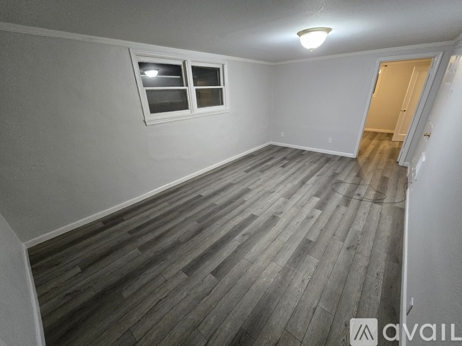 A room with wooden flooring and a window.