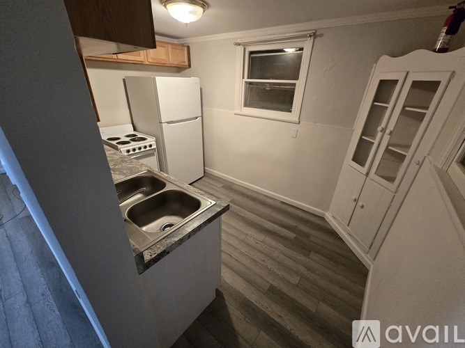 A small kitchen with a sink, stove, and refrigerator.