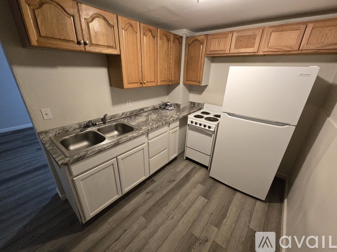 A kitchen with wooden cabinets and a white refrigerator.