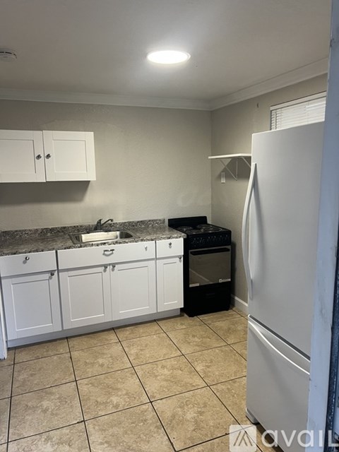 A kitchen with white cabinets and a black oven.
