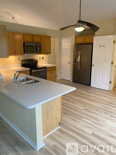 A kitchen with wooden cabinets and a white countertop.
