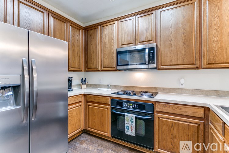 A kitchen with wooden cabinets and a stainless steel refrigerator.