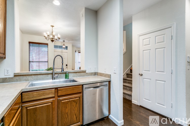 A kitchen with wooden cabinets and a stainless steel dishwasher.