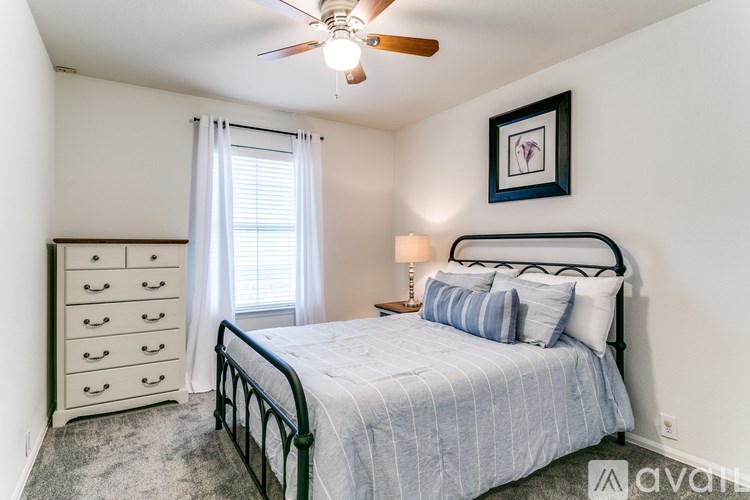 A bedroom with a bed, dresser, and window.