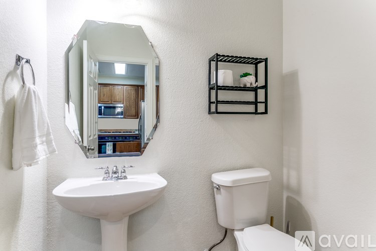 A bathroom with a white sink and toilet.