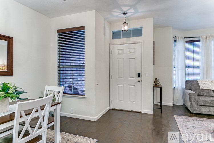 A well-lit room with a dining table and chairs.