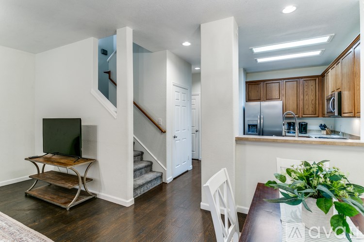 A modern living room with a television and a staircase.