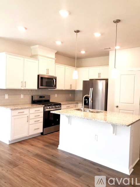 A kitchen with white cabinets and a granite countertop.