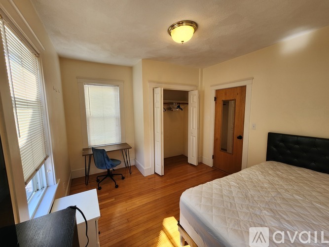 A room with wooden floors and two windows.