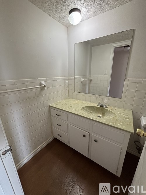 A backyard with a wooden fence and a concrete path.