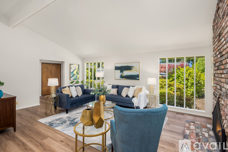 A living room with a blue couch and a gold side table.