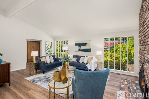 A living room with a blue couch and a gold side table.