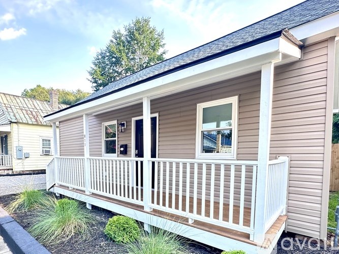 A small house with a porch and a window.