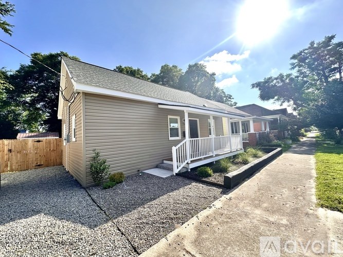 A mobile home with a gravel driveway in front.