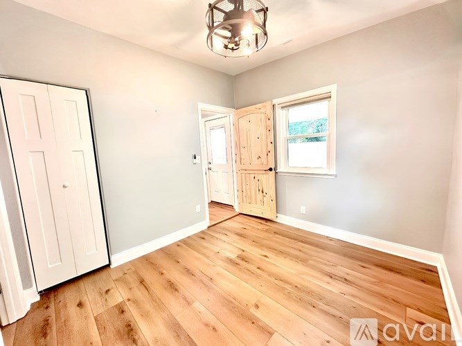 A room with wooden floors and a white door.