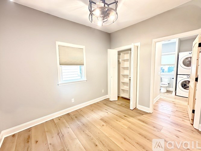 A room with wooden floors and a window with blinds.