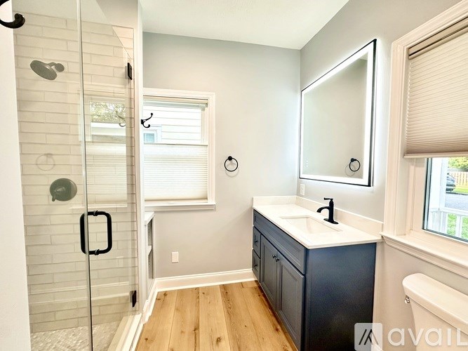 A bathroom with a white sink and a glass shower door.