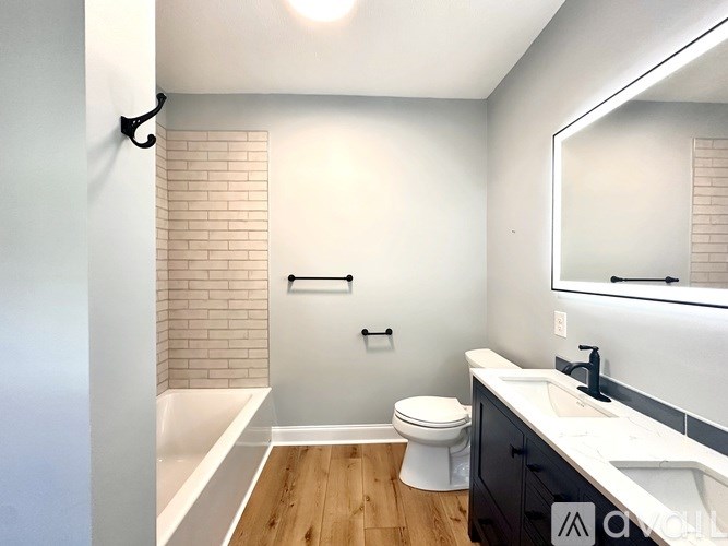 A bathroom with a toilet, sink, and a mirror.