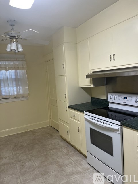 A kitchen with a white oven and a fan on the ceiling.