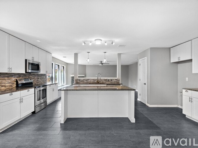 A modern kitchen with white cabinets and a central island.