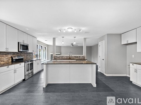A modern kitchen with white cabinets and a central island.