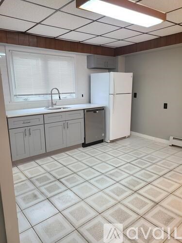 A kitchen with white cabinets and a white fridge.