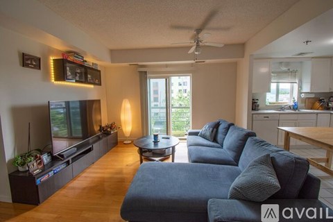 A living room with a grey sofa and a television on the wall.