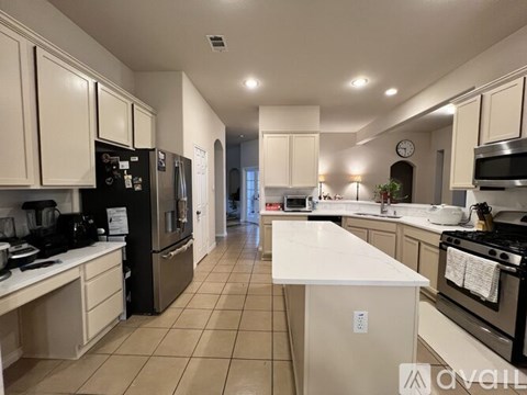 A kitchen with white cabinets and appliances.