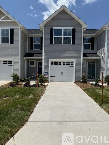 A row of houses with the first one having a garage door open.