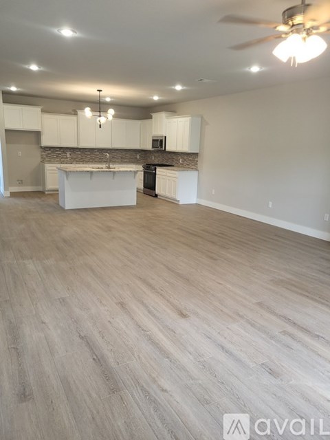 A spacious kitchen with white cabinets and a central island.