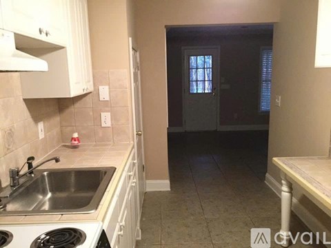 A kitchen with white cabinets and a stove top oven.