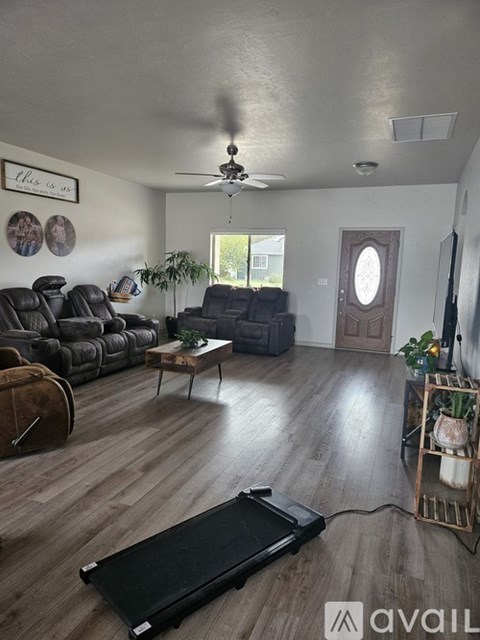A living room with a black sofa and a wooden floor.